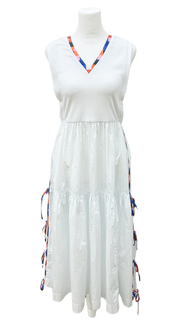 White dress with colorful trim on a mannequin against a white background