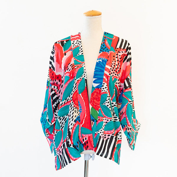 Colorful patterned jacket on a mannequin against a white background