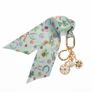 Decorative keychain with a patterned ribbon and gold charm on a white background