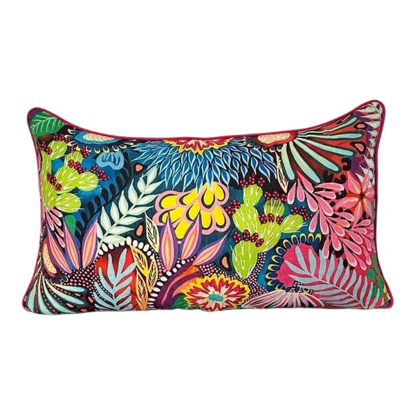 Colorful floral and cactus patterned pillow on a white background