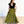 Woman wearing a black top and green patterned skirt on a white background