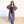 Woman wearing a colorful patterned kimono over a green top and blue jeans on a white background