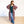 Woman wearing a colorful patterned kimono over a green top and jeans on a white background