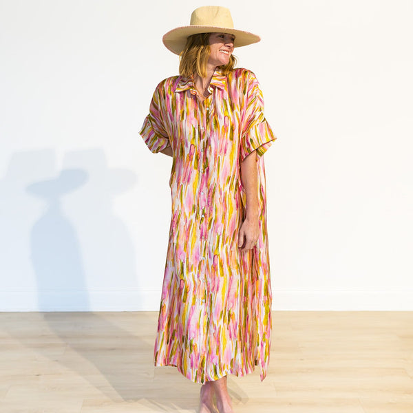 Woman wearing a colorful dress and hat on a white background