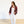 Woman wearing a floral jacket, white top, and white pants on a plain background