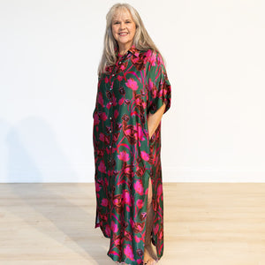 Woman wearing a colorful floral dress against a white background