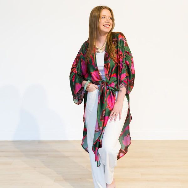 Woman wearing a colorful kimono-style garment on a plain background