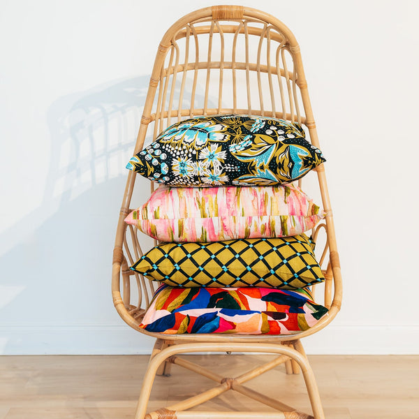 Wicker chair with colorful cushions on a white background