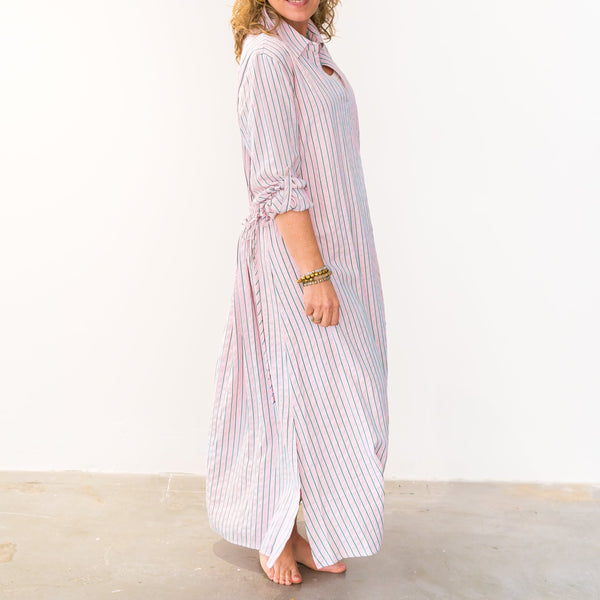 Woman wearing a long striped dress on a white background