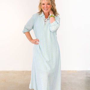 Woman wearing a light blue striped dress against a white background