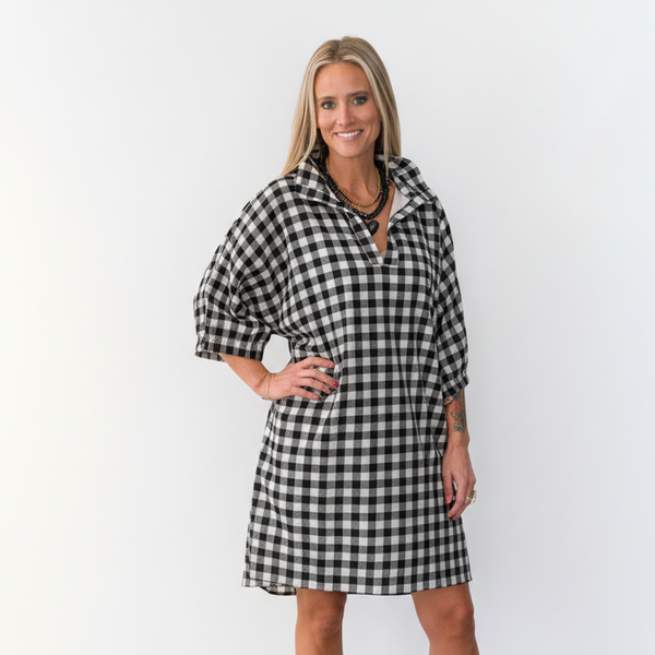 Woman wearing a black and white checkered dress against a white background